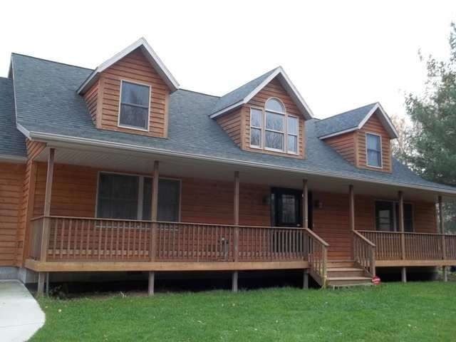 Cedar sided, 50 feet of covered front porch, this 