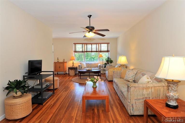 This oversized living room features two seating areas, high ceilings and large windows with custom wood blinds.