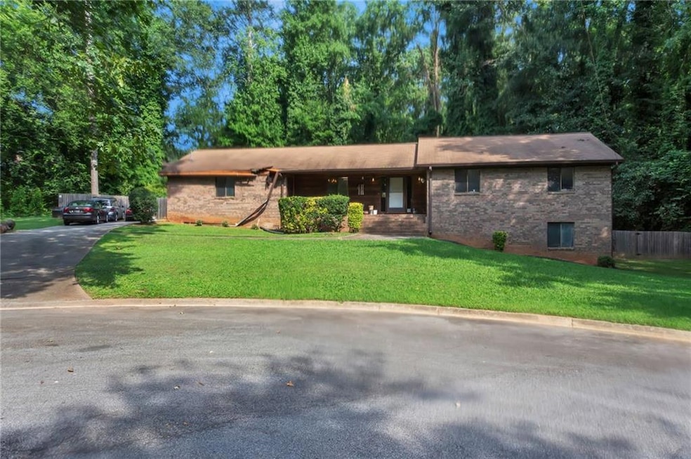 Ranch-style home featuring a front lawn and brick siding