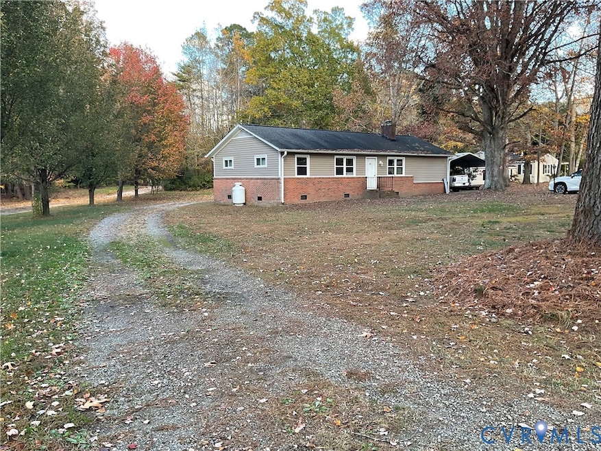 Ranch-style home with brick siding, driveway, and a front yard