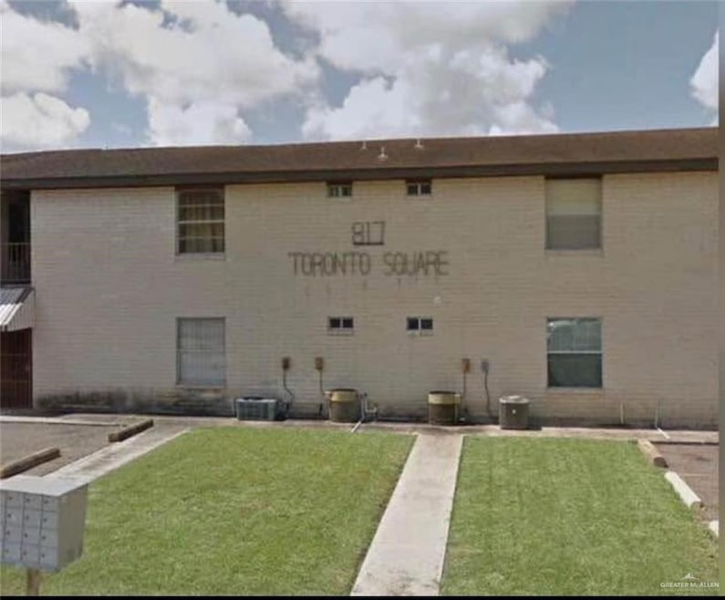 View of building exterior featuring central AC unit
