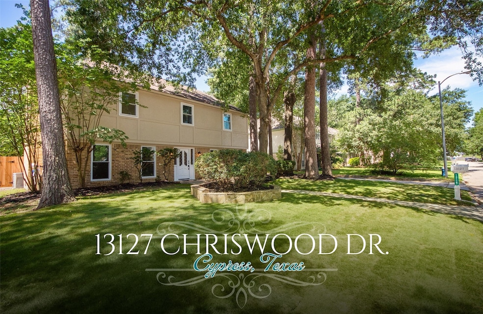 Landscaping in the front lawn features beautiful mature trees and zoysia grass.