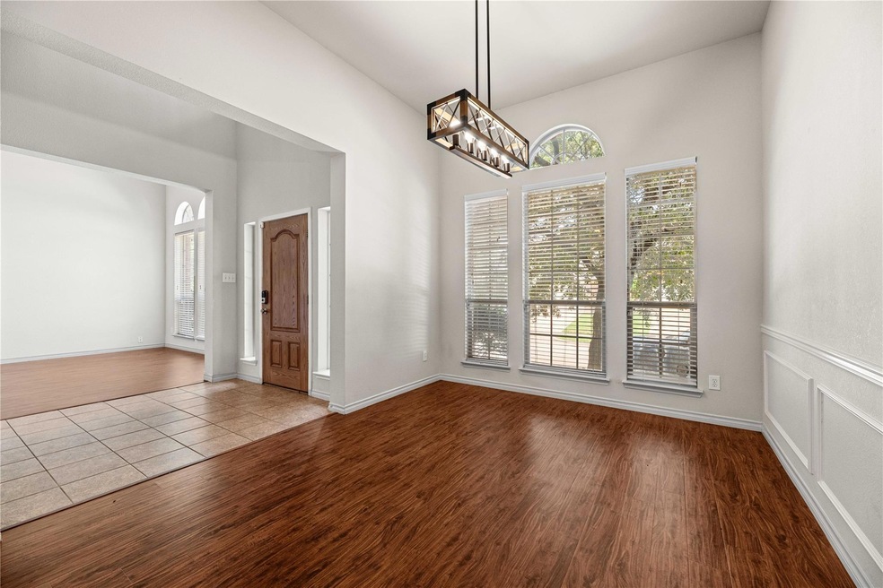 Empty room featuring a notable chandelier and wood