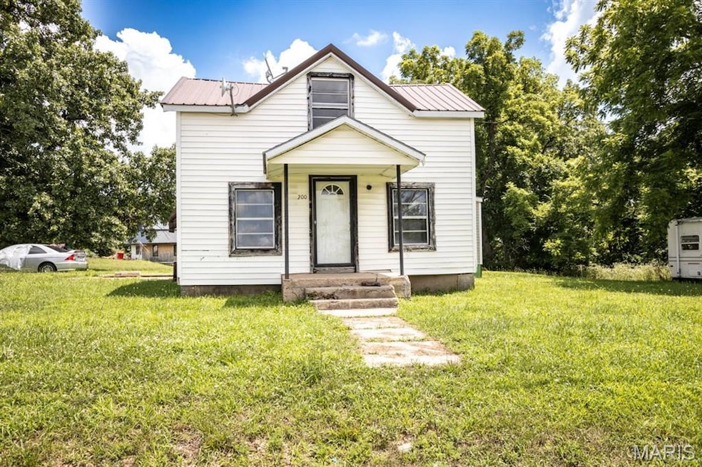 View of front of home featuring a front lawn and a metal roof