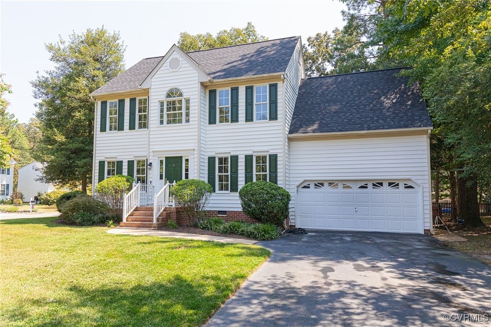 Colonial-style house featuring a garage and a front yard