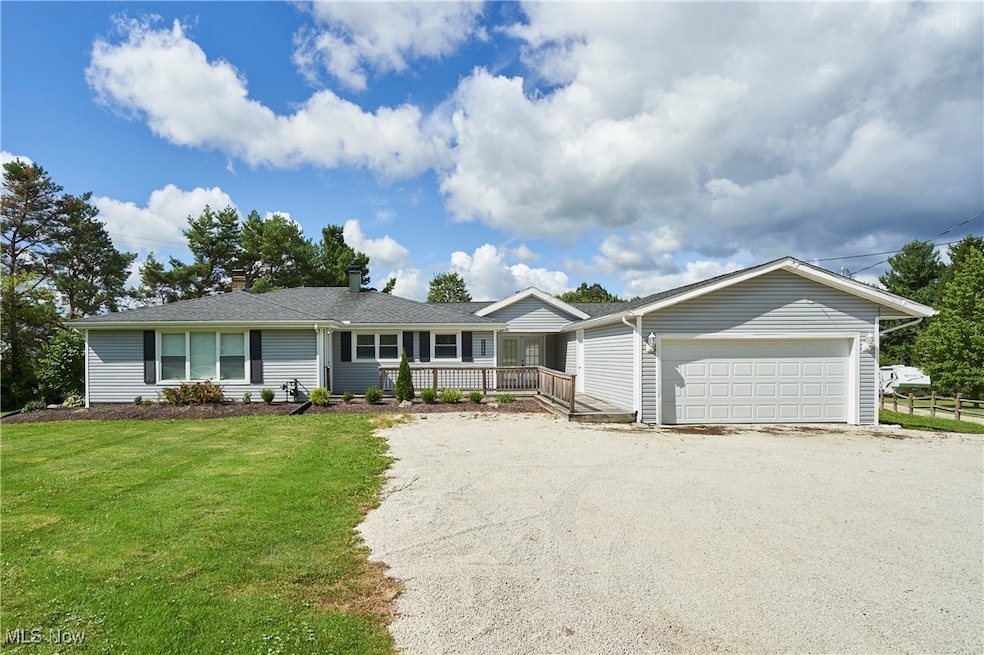 Ranch-style home with driveway, a front lawn, a garage, and a chimney