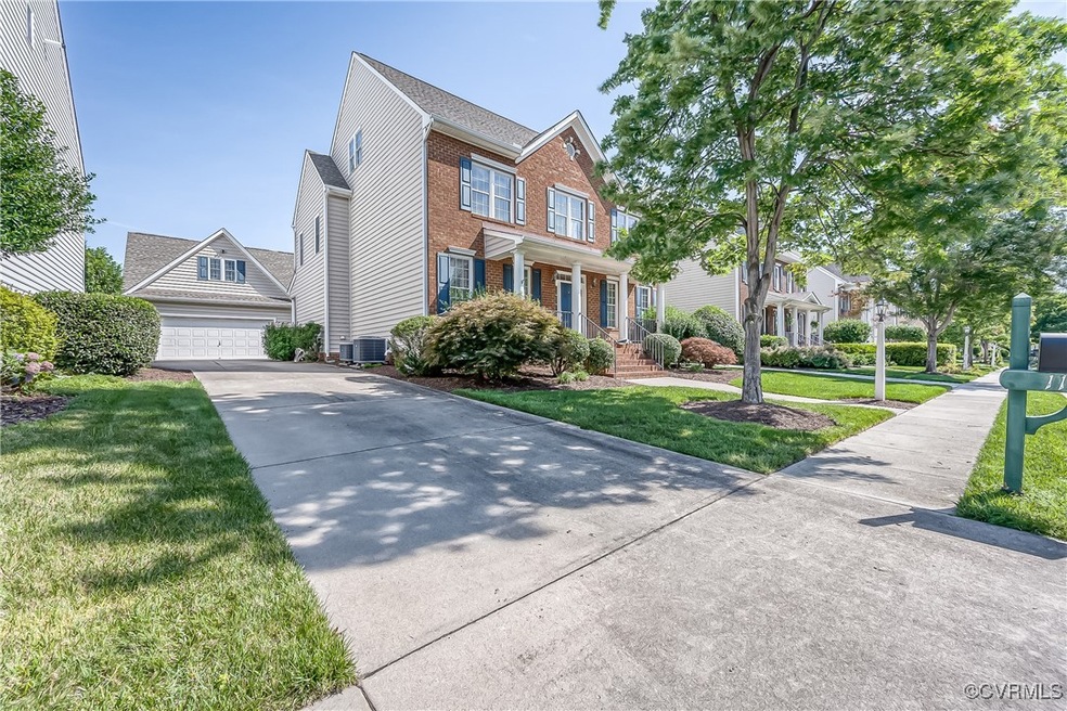 View of front facade with a garage, brick siding, a front yard, and driveway