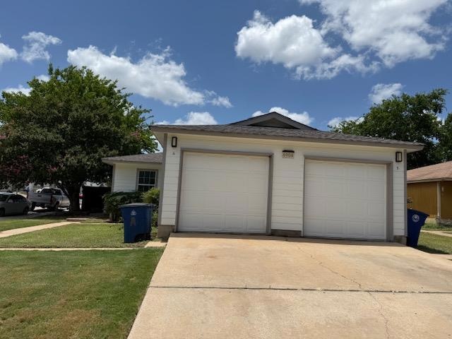 View of front of house with a front yard, a detac