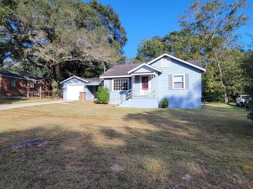 View of front facade with an outdoor structure, a front lawn, and driveway