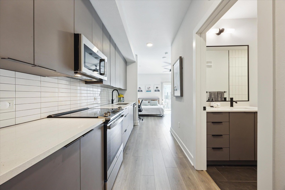 Kitchen with stainless steel appliances, gray cab