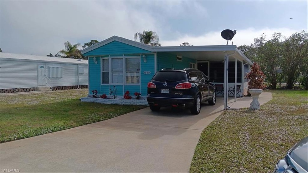 View of front of property featuring a front lawn and a carport