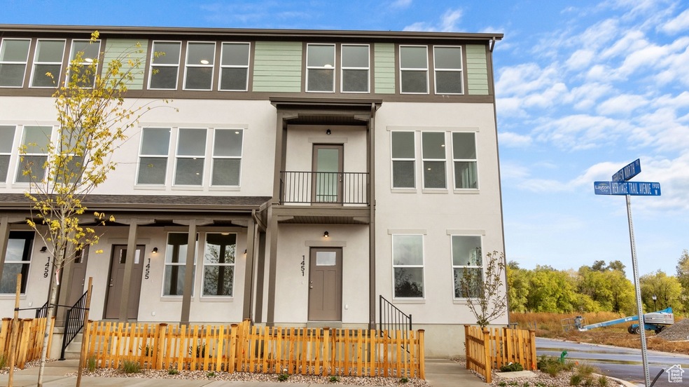 View of front of house with stucco siding, a balcony, and a fenced front yard