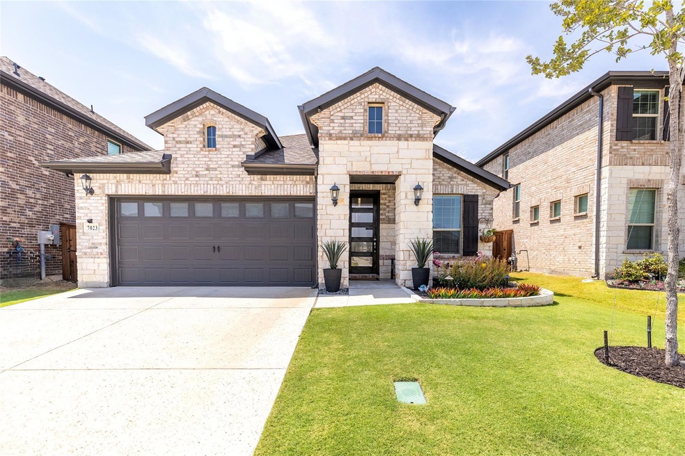 View of front of house featuring a front lawn and a garage