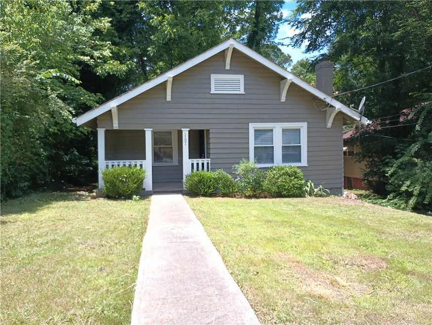 Bungalow-style house with a front yard, covered po