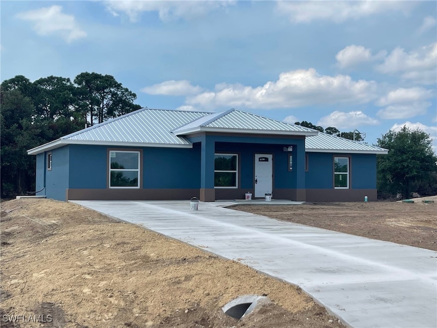 Single story home featuring metal roof, stucco sid