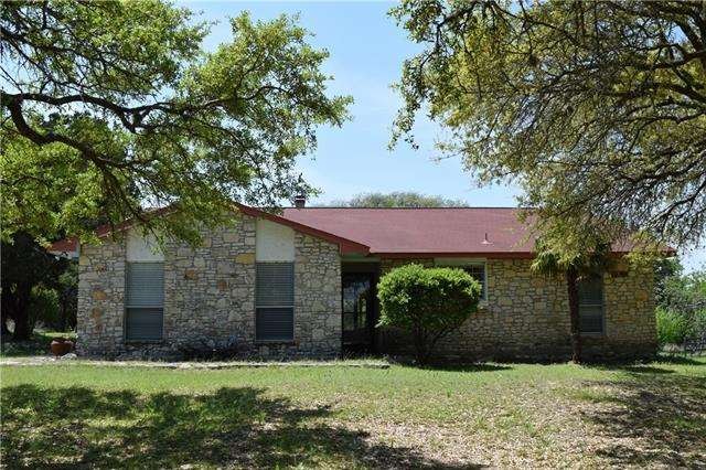 Front of home framed by beautiful oak trees.