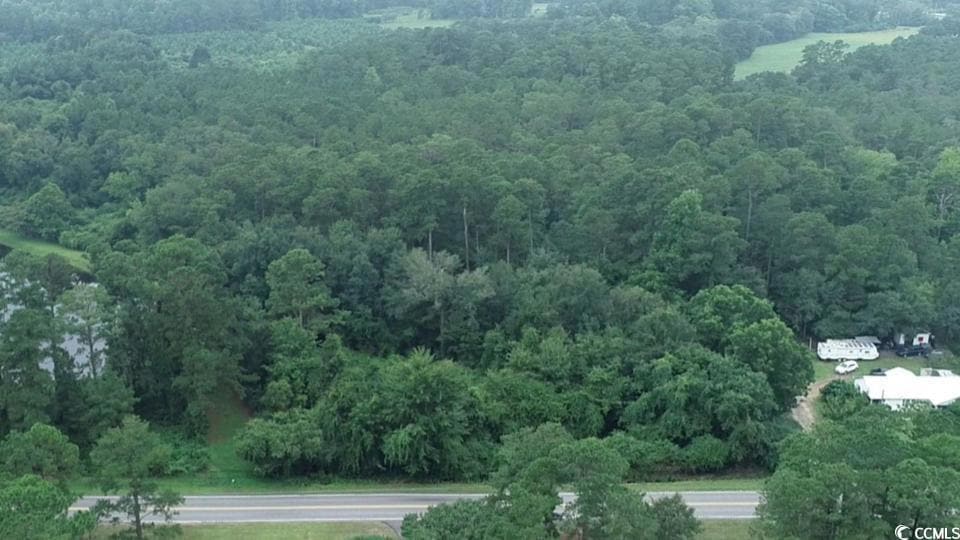 Aerial view of property's location featuring a heavily wooded area