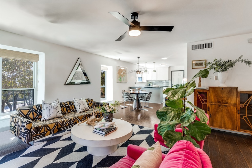 Living area featuring dark wood-style flooring and ceiling fan