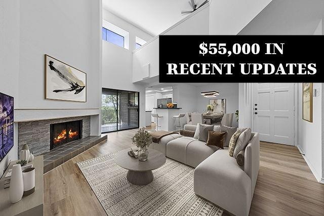 Living area with plenty of natural light, a high ceiling, finished floors, a fireplace and built-in shelves