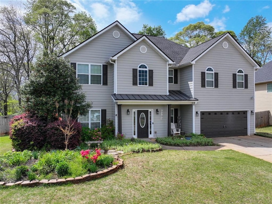 Traditional home with a front yard, an attached ga