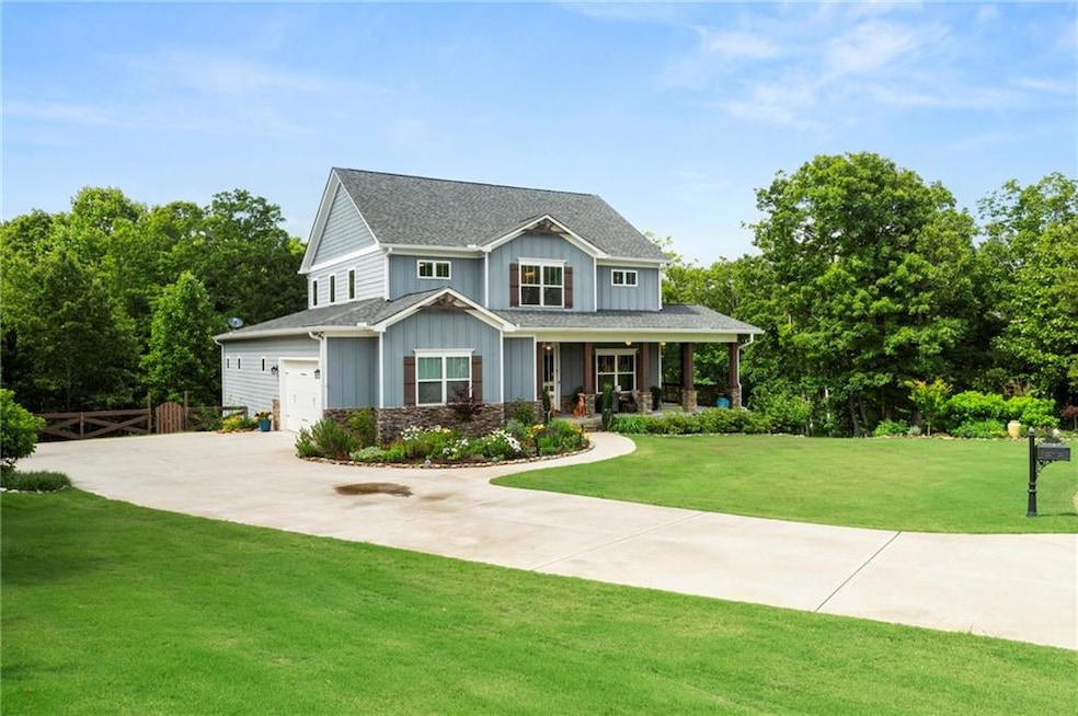 Craftsman inspired home with board and batten siding, covered porch, driveway, and a garage