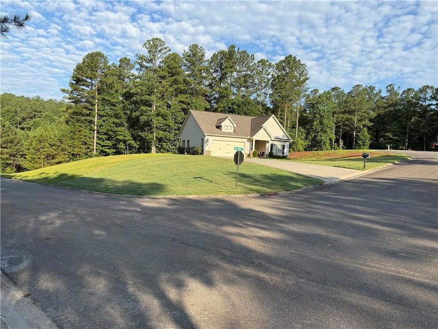 View of front of house featuring driveway, a front yard, and an attached garage