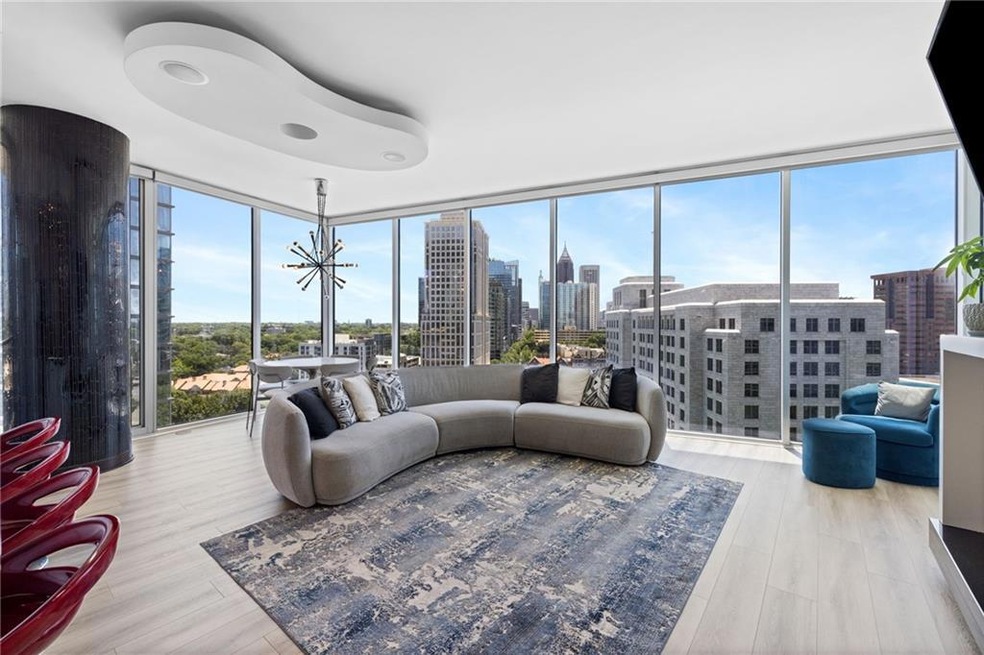 Living area featuring a wall of windows, wood finished floors, and a chandelier