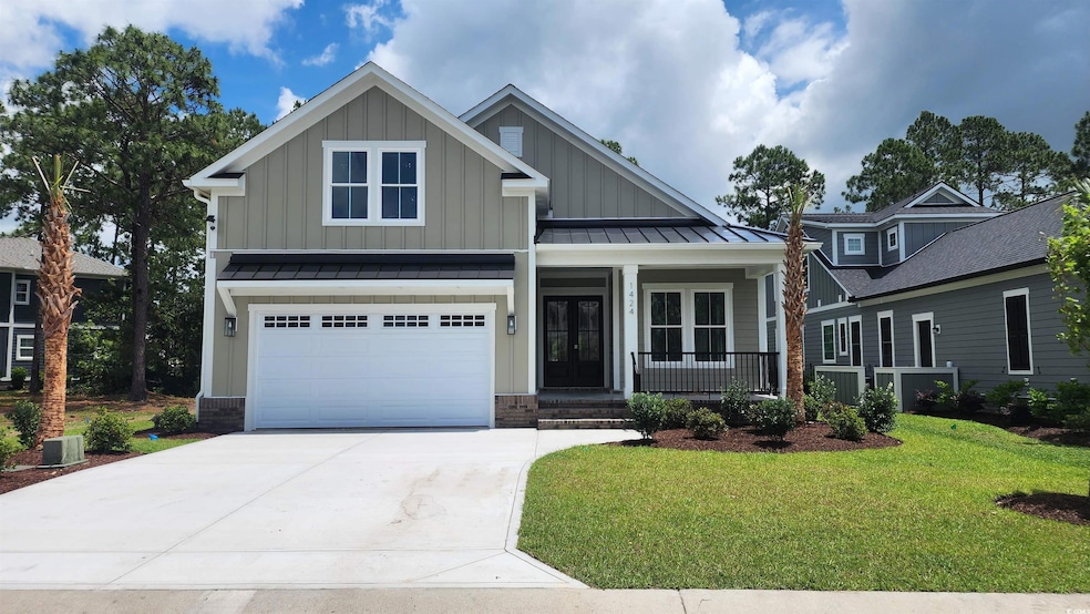Craftsman house featuring board and batten siding, covered porch, a front lawn, and concrete driveway