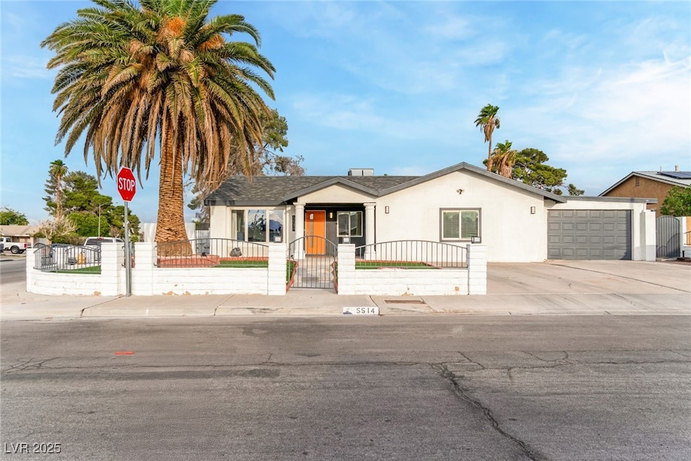 View of front of property with stucco siding, a fenced front yard, concrete driveway, and a gate