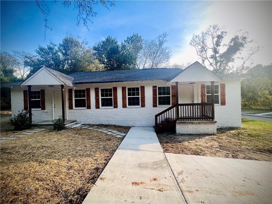 Ranch-style house with a porch, brick siding, and 