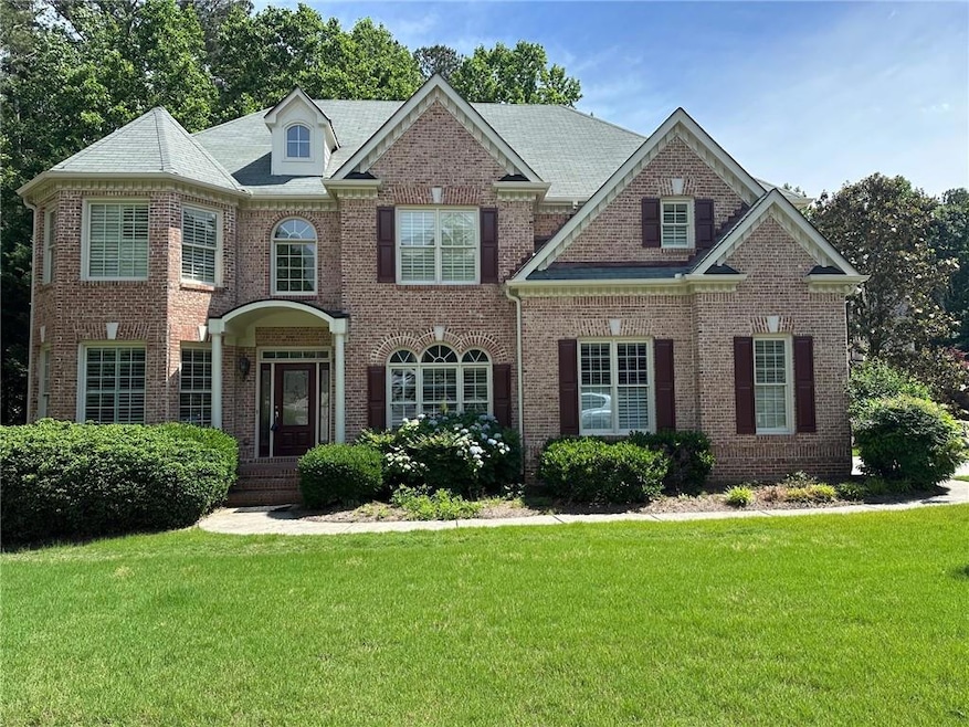 Colonial inspired home featuring brick siding and a front yard