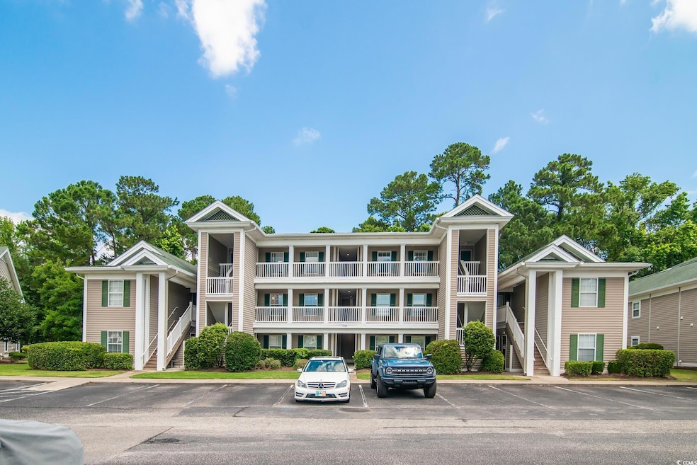 View of property featuring uncovered parking and stairs