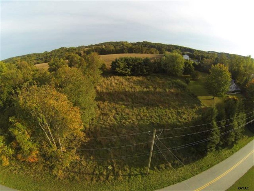 Field to right to wooded area. This shot faces sou