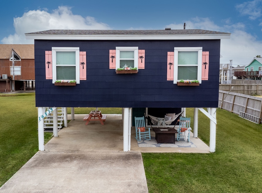 Elevated coastal home with a charming navy exterio