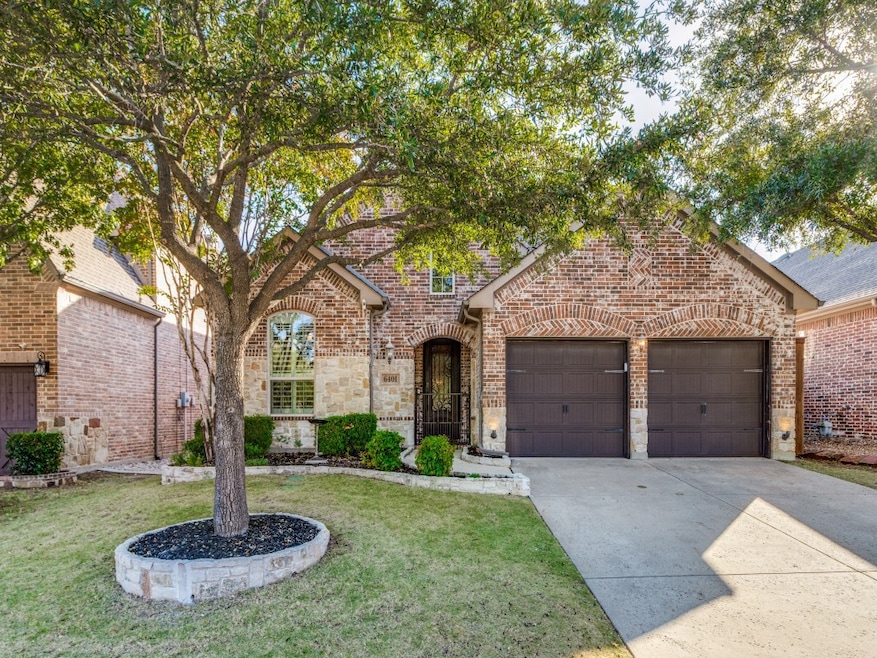View of front facade featuring concrete driveway, brick siding, a front lawn, and a garage