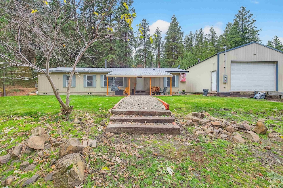 Single story home with a front lawn, crawl space, a garage, and a metal roof