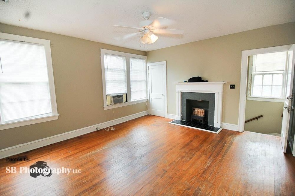 Unfurnished living room with ceiling fan and hardw