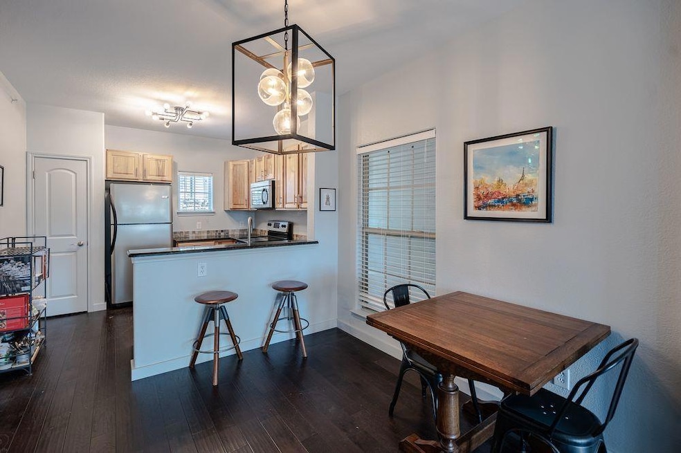 Dining area with dark wood-style flooring and bas