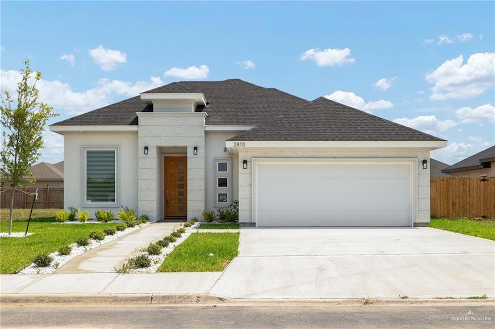 View of front of property featuring a shingled roof, driveway, a garage, and stucco siding