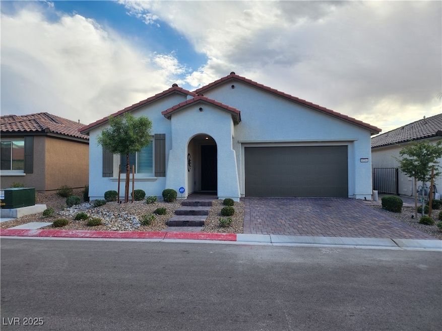 Mediterranean / Spanish house with stucco siding, decorative driveway, a garage, and a tile roof