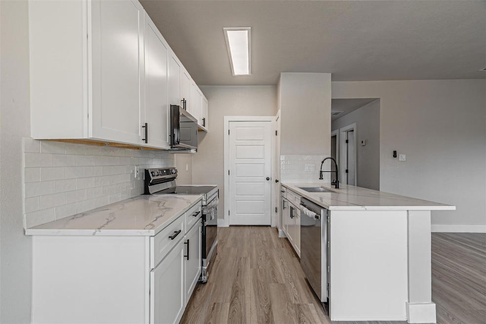 Kitchen with light wood-style flooring, a sink, st