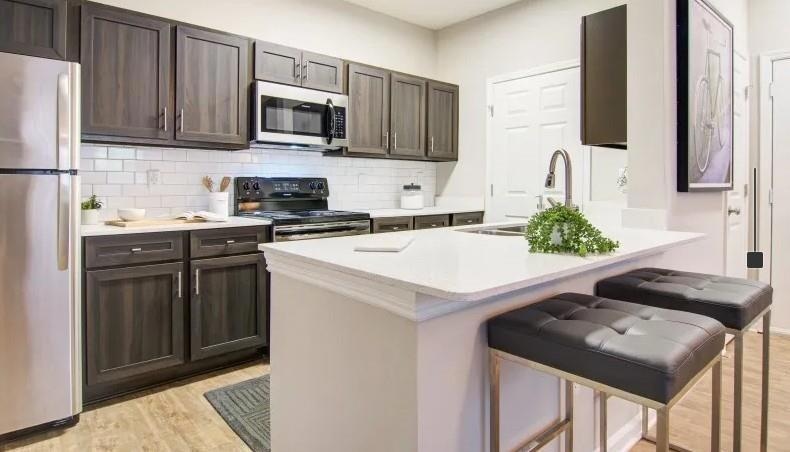Kitchen featuring a sink, light countertops, appli