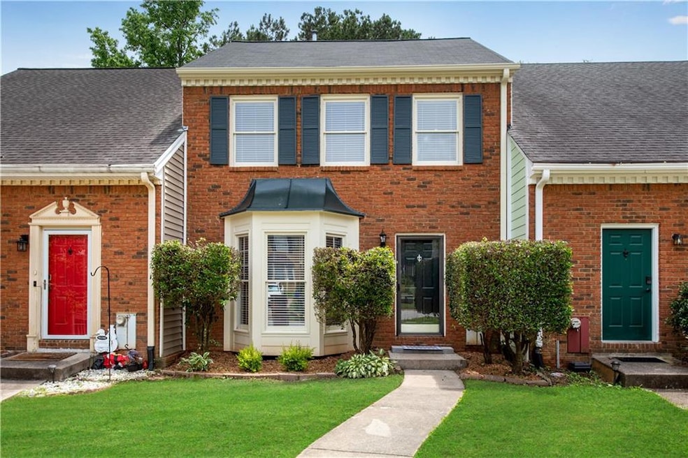 Charming duplex with matching brick façade and colorful front doors.