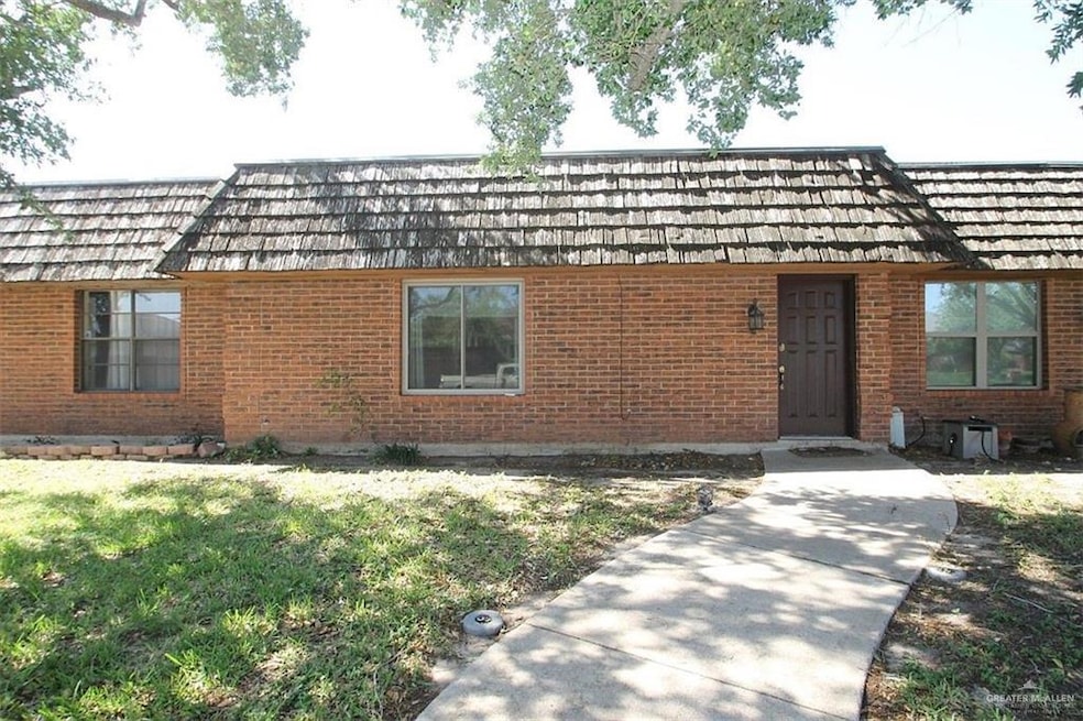 View of front of property featuring a front lawn and brick siding
