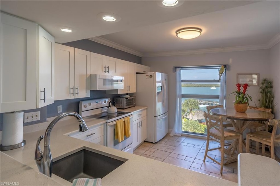 Kitchen featuring white cabinets, white appliances