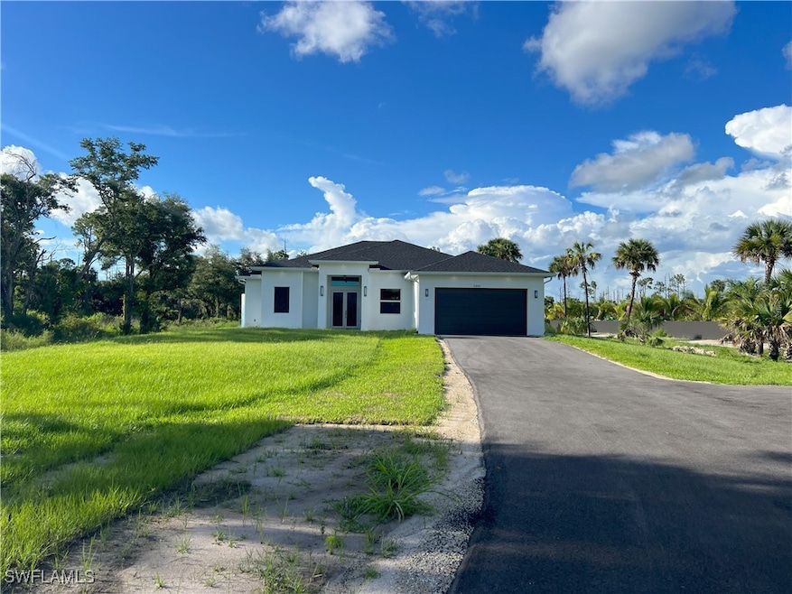 View of front of home with a front lawn and a gara