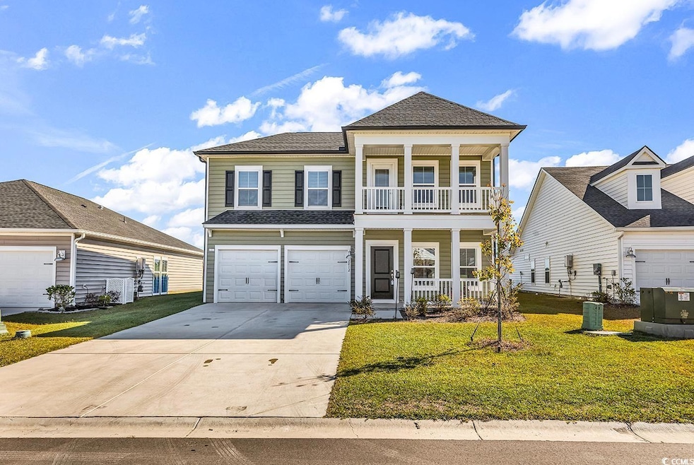 View of front of home featuring covered porch, driveway, a front lawn, and a garage