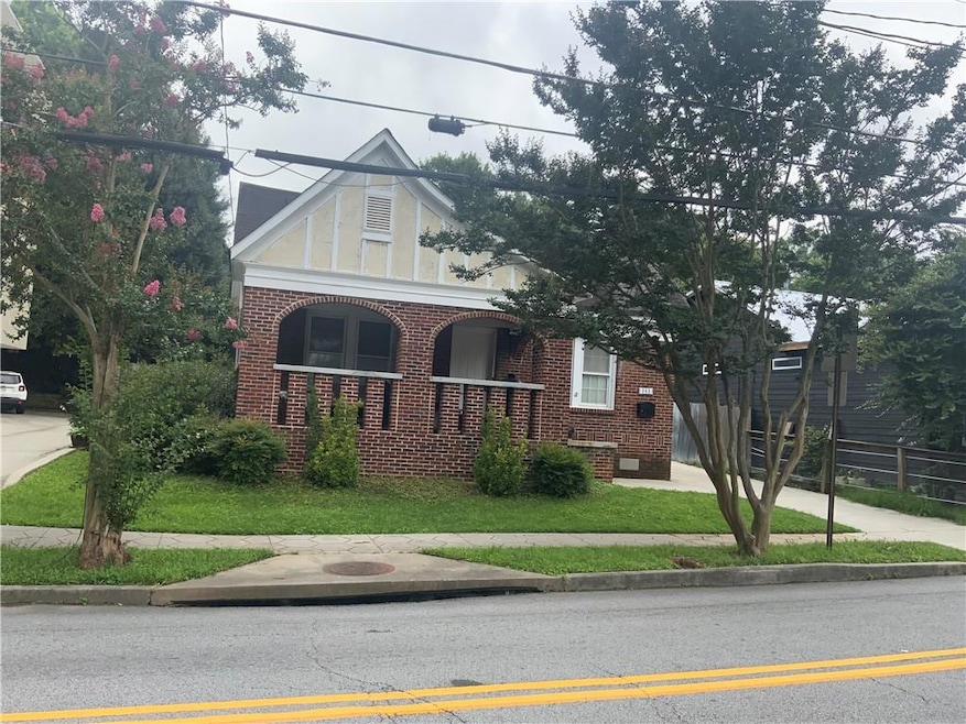 English style home with brick siding, a porch, and crawl space