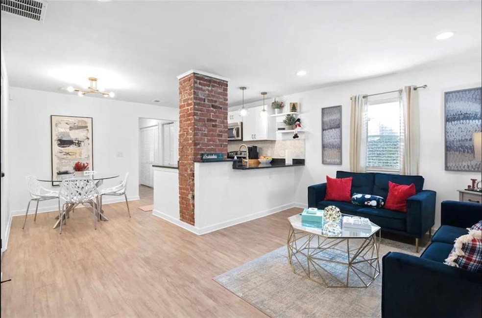 Living area with light wood-style floors, recessed lighting, baseboards, and a chandelier