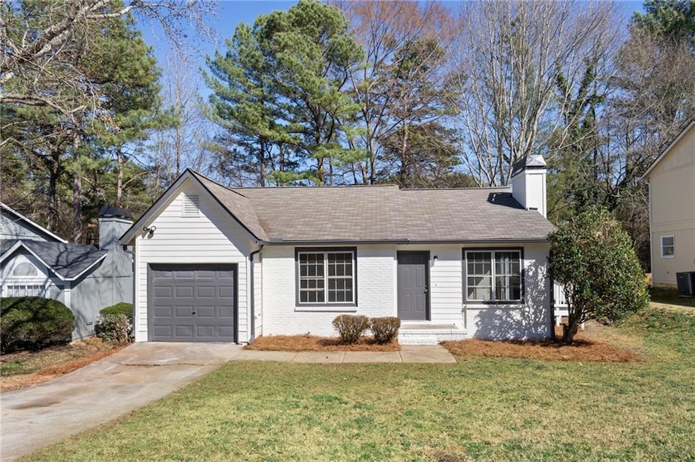 Ranch-style home featuring a front yard, an attach